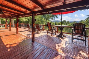 A wooden deck with outdoor seating, including chairs and a table, overlooking a scenic landscape. - Heavenly Mountain VIew, Hot Tub, Fire Pit (Blue Ridge)