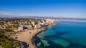 An aerial view of a coastal city with a beach, buildings, and clear blue waters. - Modern house Menut in Sa Pobla with jacuzzi (Sa Pobla)
