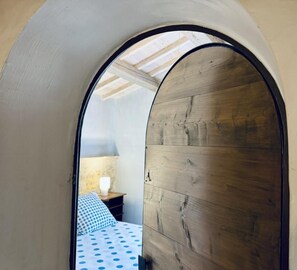 A bedroom with a wooden ceiling and a bed with a polka dot bedspread. - Le Jardin de Marie - TALAIRAN (TALAIRAN)