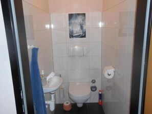 A small bathroom with a toilet, sink, and a towel rack.