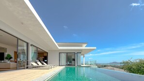A modern house with a pool, large windows, and a view of the landscape. - The Salin Seaview Villas (Rawai)