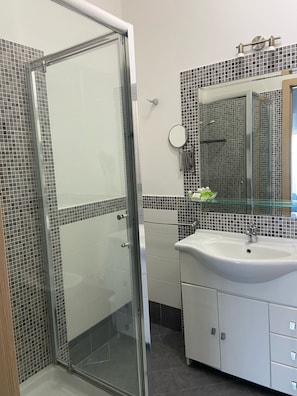 Quarto quádruplo clássico, sacada, vista para o mar | Banheiro | Chuveiro, secador de cabelo, toalhas de banho, sabonete