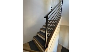 A staircase with wooden steps and a metal handrail.