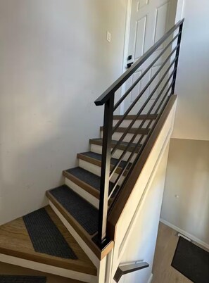 Eine Treppe mit Holzbodenstufen und einem Metallgeländer.