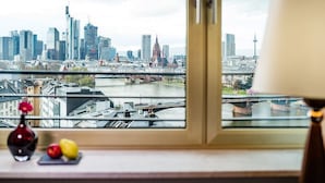 Uitzicht op de stad vanuit een raam, met een lamp aan de rechterkant.