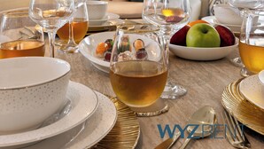 A dining area with a table set for a meal, including plates, glasses, and a bowl of fruit.