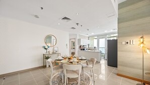 A modern dining area with a round table, chairs, and a decorative mirror.