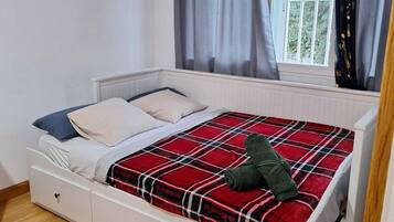 Un dormitorio con cama, ventana y aire acondicionado.