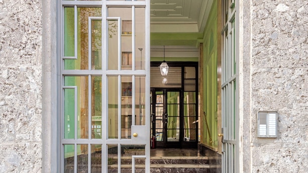 A building entrance with a stone facade, a metal gate, and a staircase leading inside. - Luxury Penthouse 2 Bedooms 2 Bathrooms (Milan)