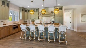 A kitchen with a central island, four bar stools, and pendant lighting. - Elegance~Gorgeous! Arcade!~ Heated pool/spa~North End! (Anna Maria)