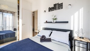 Een moderne hotelkamer met een bed, nachtkastje, een wandplank en een cactus decoratie.