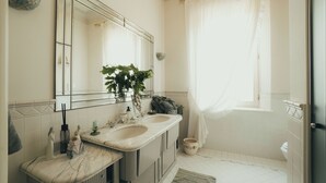 A bathroom with two sinks, a large mirror, a potted plant, and a toilet. - Suite Seta (Castelvetro di Modena)