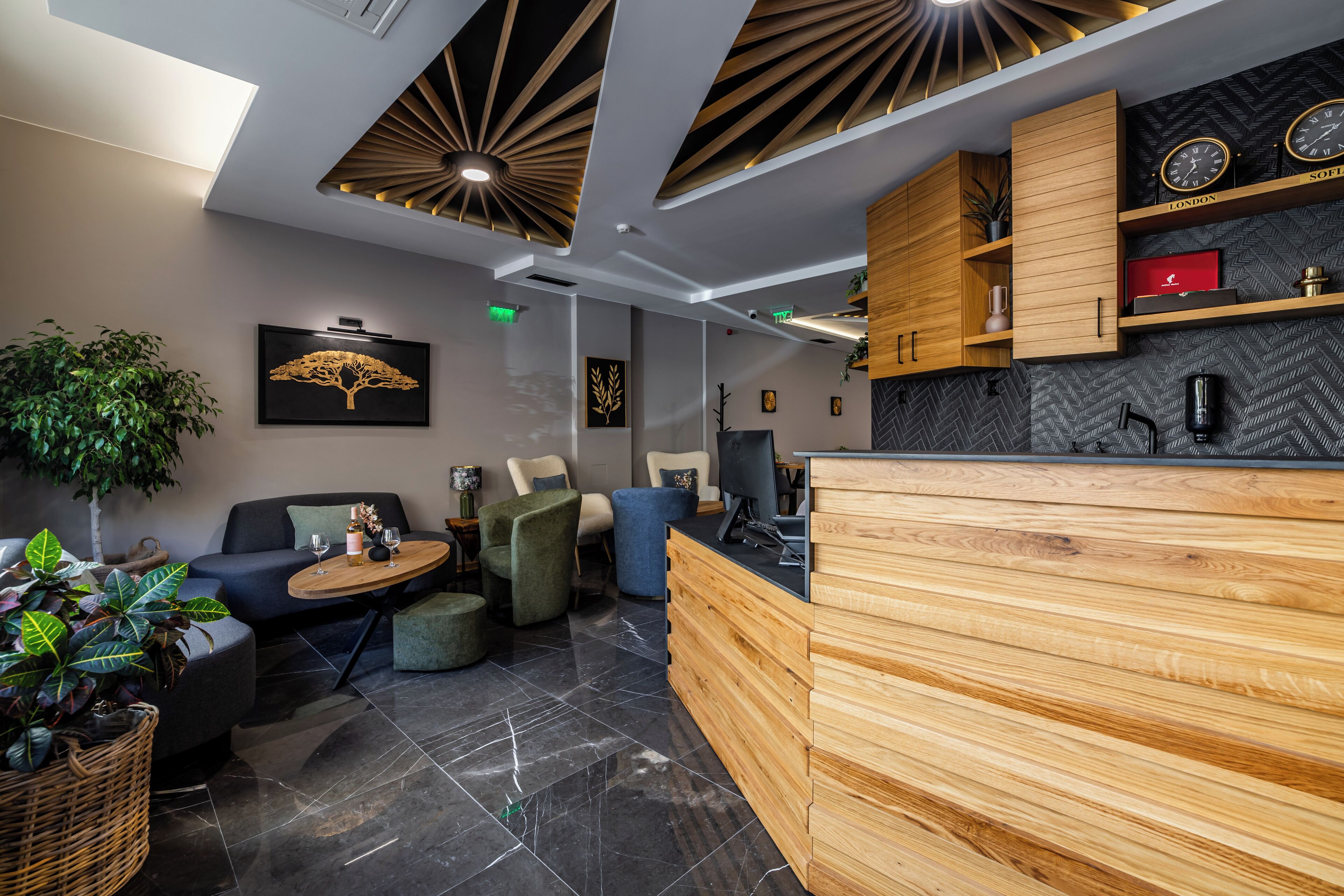A modern reception area with a wooden desk, seating area with sofas, and a herringbone-patterned wall.