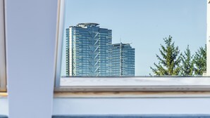 A bedroom with a bed, a window, and a view of tall buildings. - Acacia Boutique Hotel (Sofia)