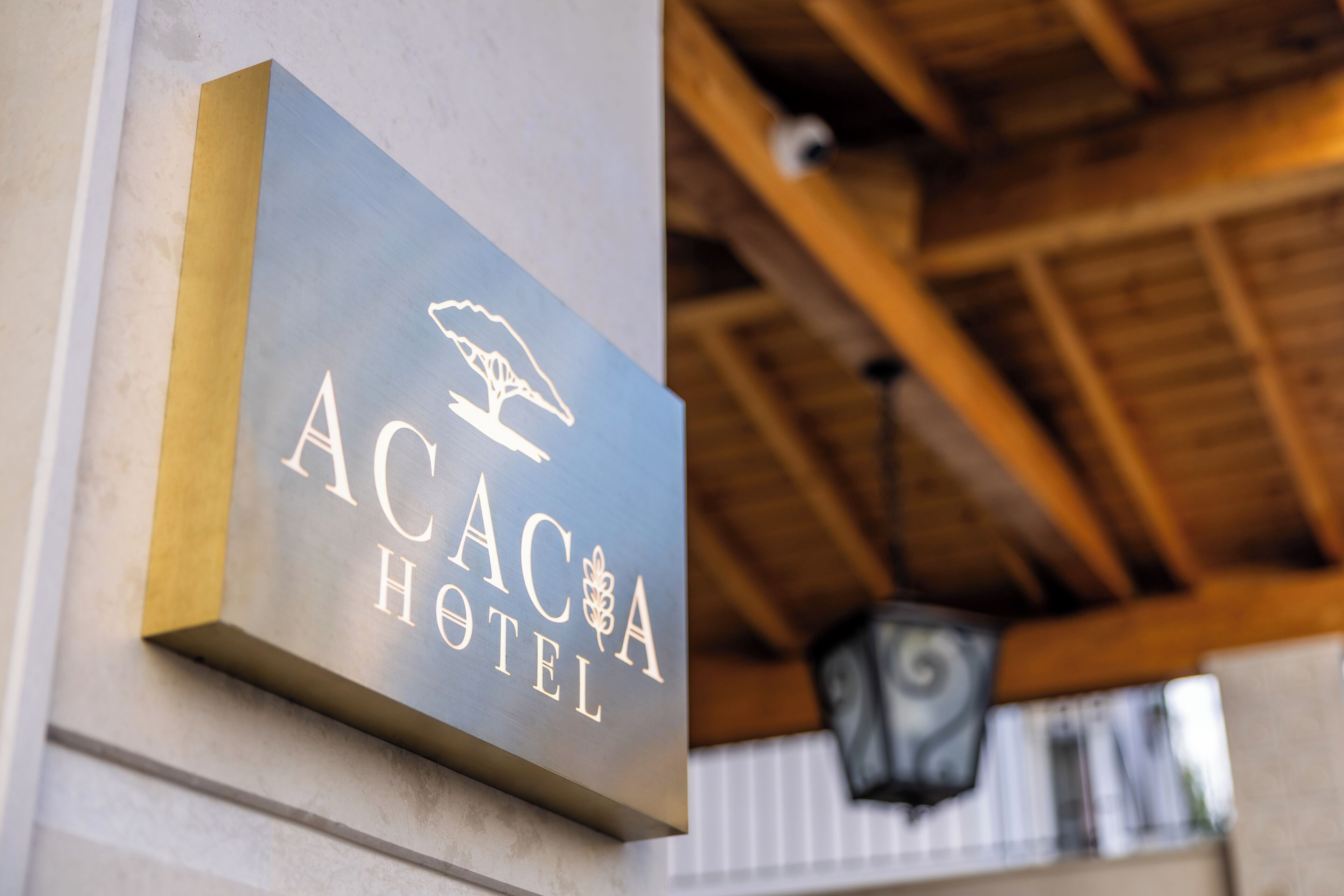 A sign for the Acaca Hotel with a bird logo.