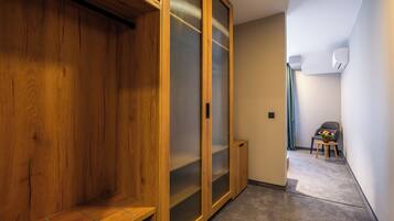 A hallway with wooden flooring, a sliding glass door, and a small table with flowers.