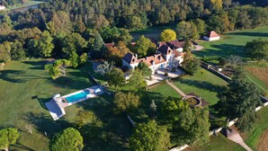 An aerial view of a large estate with a swimming pool, multiple buildings, and extensive greenery. - Château Ecrin de lumiere (Campsegret)