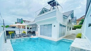 Ein modernes Haus mit Swimmingpool, Balkon und einer Terrassenanlage.