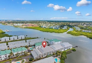 Un hôtel situé sur la côte, composé de plusieurs bâtiments, doté d’une piscine et d’un port de plaisance.