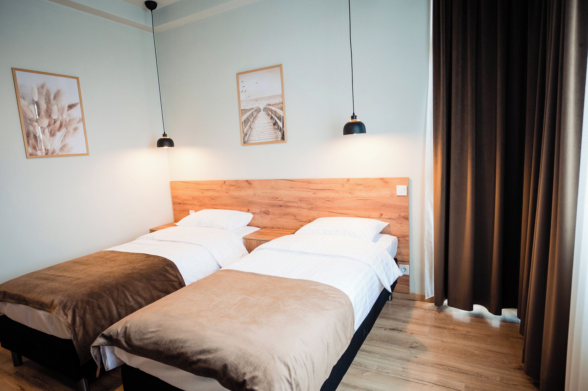 Una cama doble con cabecera de madera, dos mesitas de noche y una mesilla.