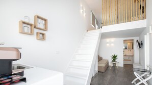 Ein modernes Interieur mit Treppe, Küchenbereich und Essplatz.