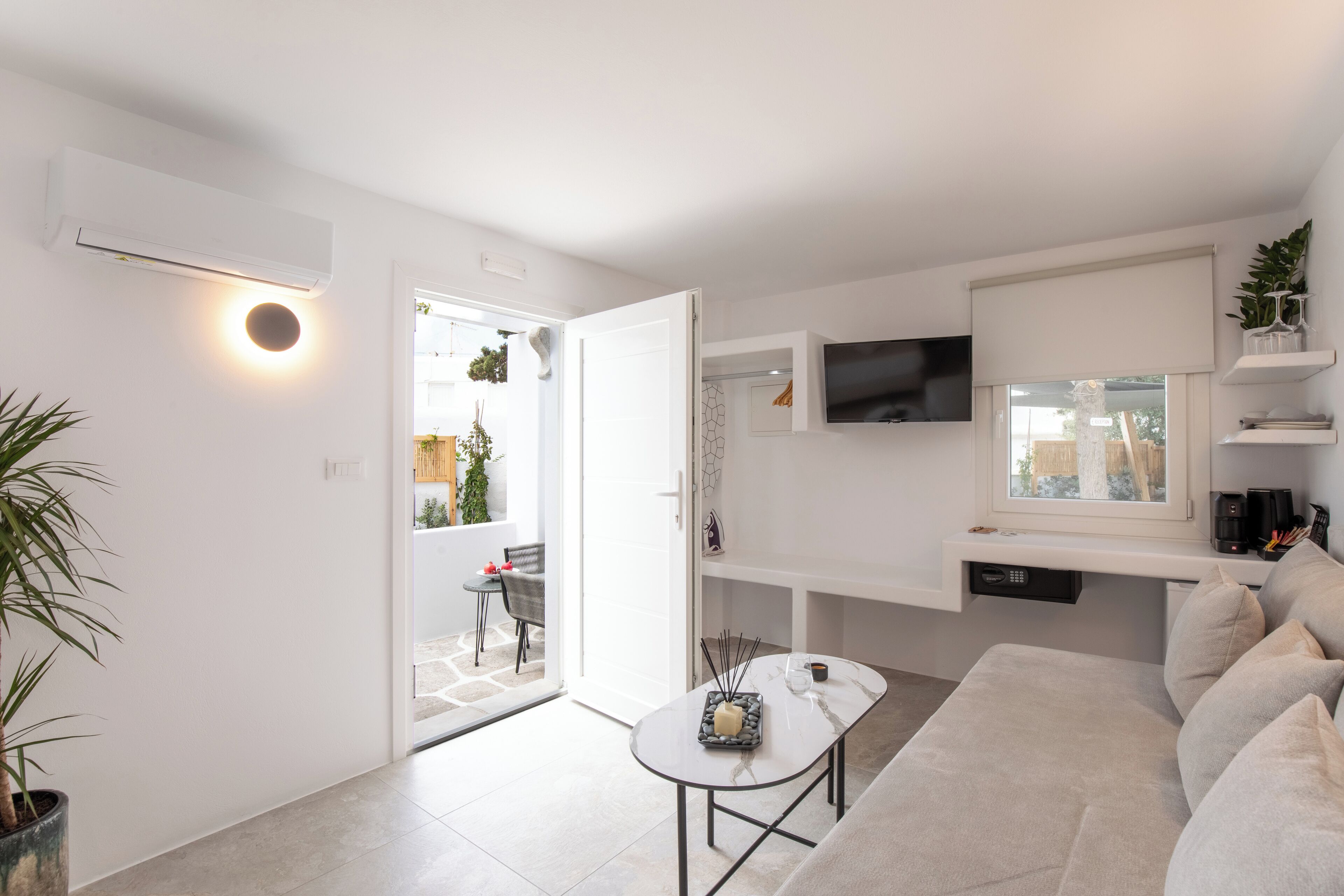 A modern living room with a sofa, a coffee table, and a TV mounted on the wall.