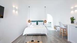 Ein modernes Hotelzimmer mit einem großen Bett, Nachttischen, einem Schreibtisch und einem Sessel.
