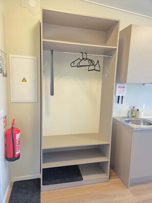 A kitchenette with a built-in oven, a sink, and a fire extinguisher. - Hotel Studlagil Canyon (Egilsstaðir)