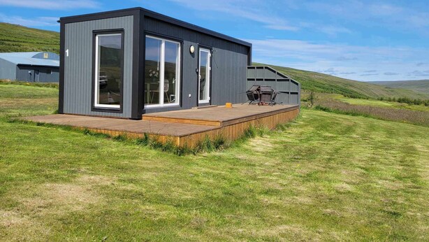 A modern, single-story building with large windows and a deck area. - Hotel Studlagil Canyon (Egilsstaðir)