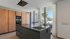 Une cuisine moderne avec des meubles en bois, un évier en acier inoxydable et un four encastré.