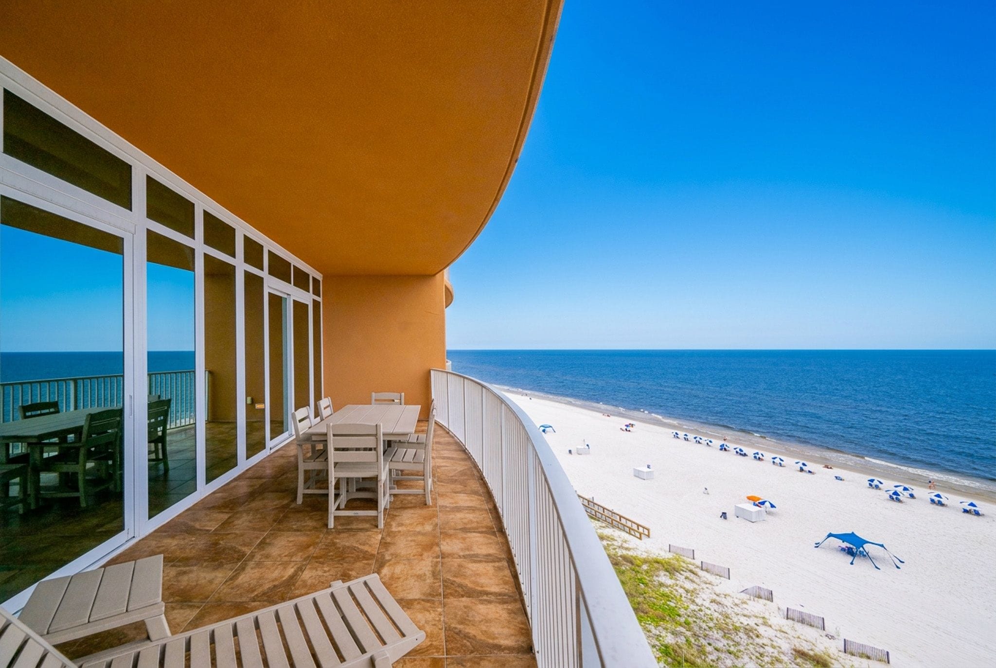A balcony with a view of a beach and ocean.