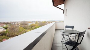 A balcony with a table and chairs, overlooking a residential area. - Stay at Georges and Fly (Otopeni)