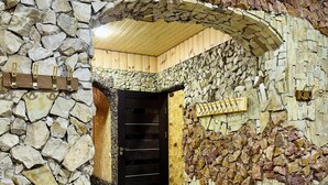 Ein Gebäude mit Steinwänden, einer Holztür und einem Fliesenboden.