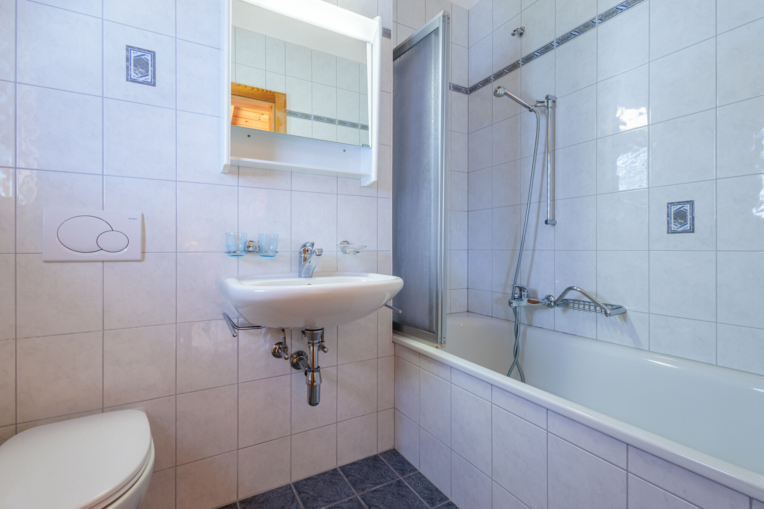 A bathroom with a toilet, sink, and shower.