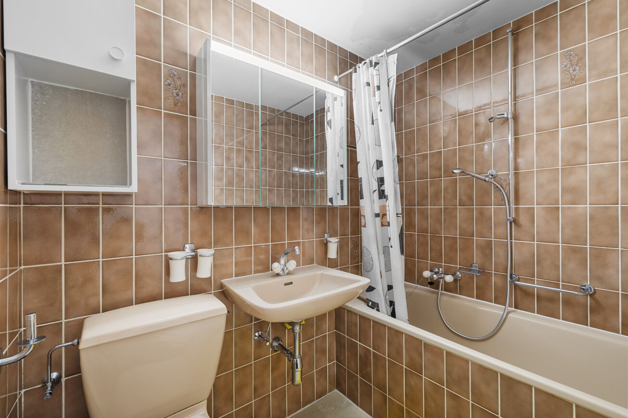 A bathroom with a toilet, sink, mirror, shower, and bathtub.
