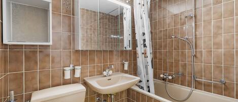 A bathroom with a toilet, sink, mirror, shower, and bathtub.