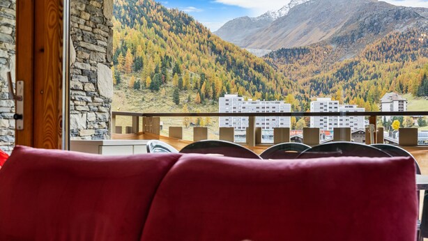 A red sofa in a room with a view of a mountainous landscape. - Dents-Rousses D4 - 4 pers - ski In&Out (Siviez)