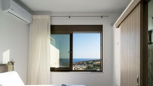 Ein Hotelzimmer mit Bett, Fenster mit Meerblick und Kleiderschrank.