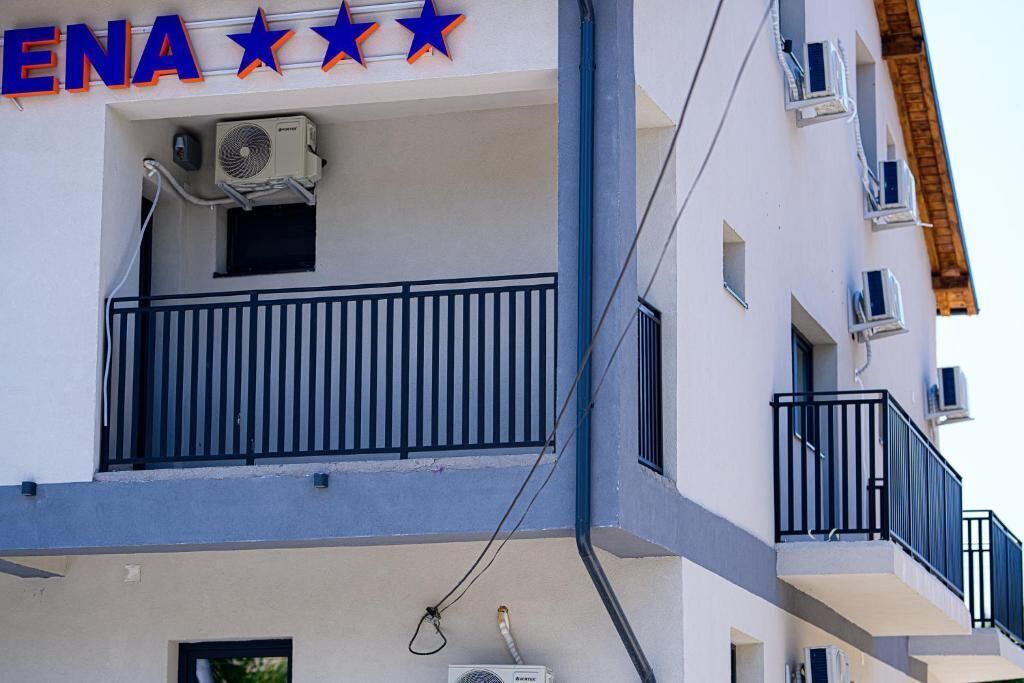 A building with the sign "ENA" and three stars above it, indicating a hotel or similar establishment.