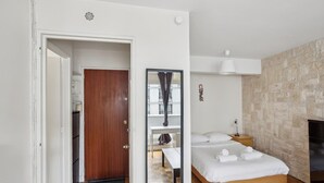Ein Schlafzimmer mit einem hölzernen Bett, einem Spiegel, einem Nachttisch und einem Kleiderschrank.