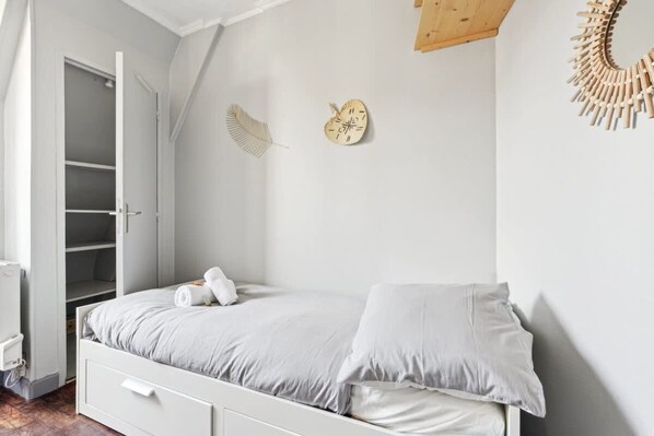 Une chambre à coucher avec un lit, une armoire et une horloge murale.