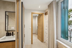 A modern bathroom with a large mirror, a sink, and a window with curtains. - Nid Douillet 2 pas du Marais (Paris)