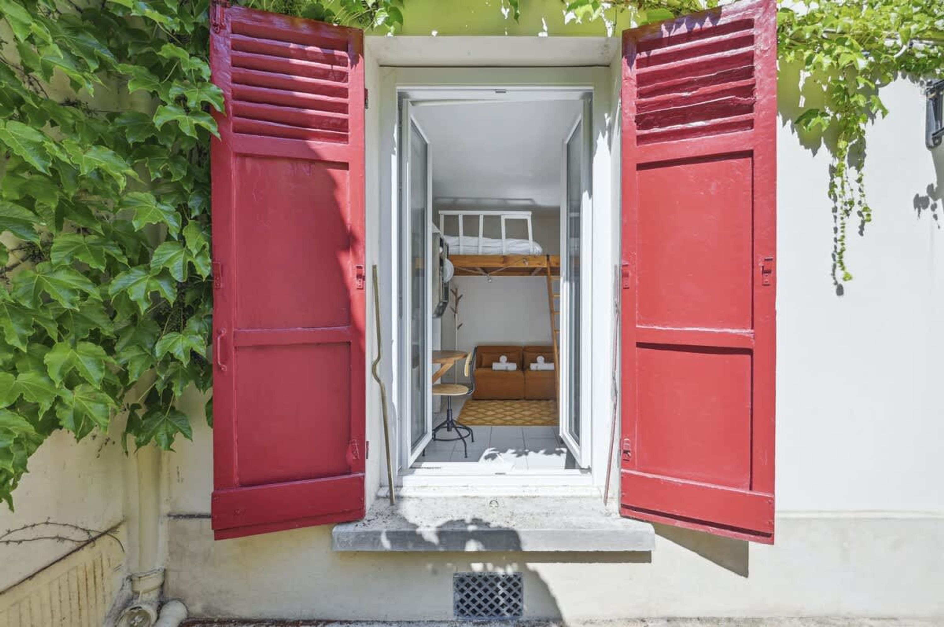 Ein kleines Zimmer mit Etagenbett, Tisch und Stuhl.