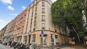 A multi-story building with a ground-floor commercial space, including a bank and a restaurant. - Warm Apartment - Montmartre - Mobility Lease (Paris)