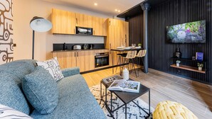 Uma sala de estar moderna com sofá, mesa de centro e área de jantar com cadeiras.