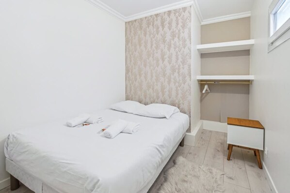 A neatly arranged bedroom with a bed, a small bedside table, and a built-in wardrobe. - Exceptional Apartment With Terrace - La D Fense (Courbevoie)