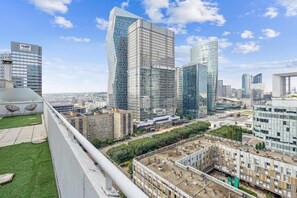 A cityscape with modern high-rise buildings, a rooftop terrace with a view of the city, and a construction site. - Exceptional Apartment With Terrace - La D Fense (Courbevoie)