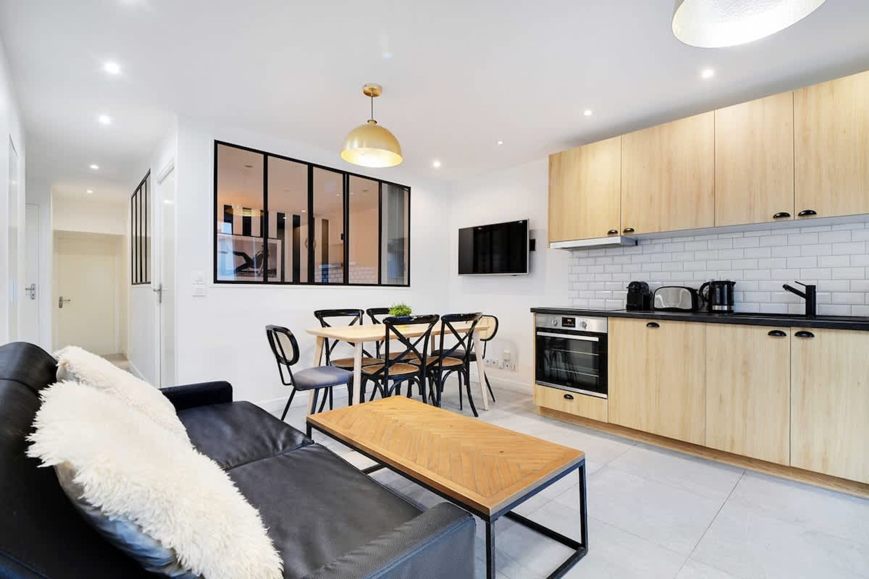 A modern kitchen with wooden cabinets, a black countertop, and a built-in oven.