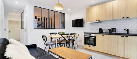 A modern kitchen with wooden cabinets, a black countertop, and a built-in oven.