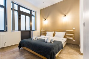 A modern hotel room with a large bed, two bedside lamps, a window with blinds, and a radiator. - Amazing Apartment - 2br6p - Bastille (Paris)